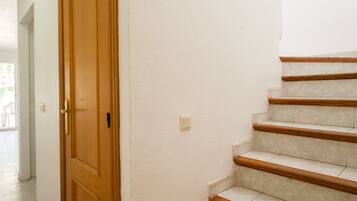 A staircase with wooden steps and a white wall.