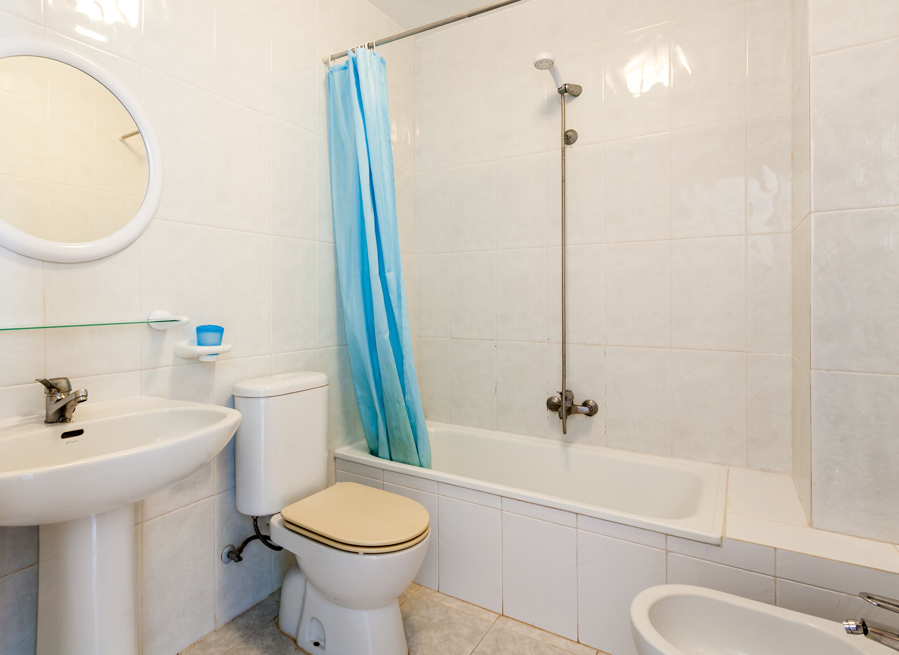 A bathroom with a toilet, sink, bathtub, and shower.