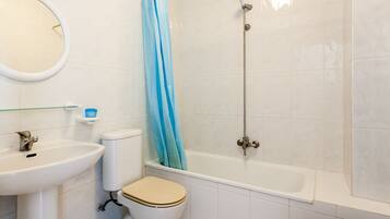 A bathroom with a toilet, sink, bathtub, and shower.