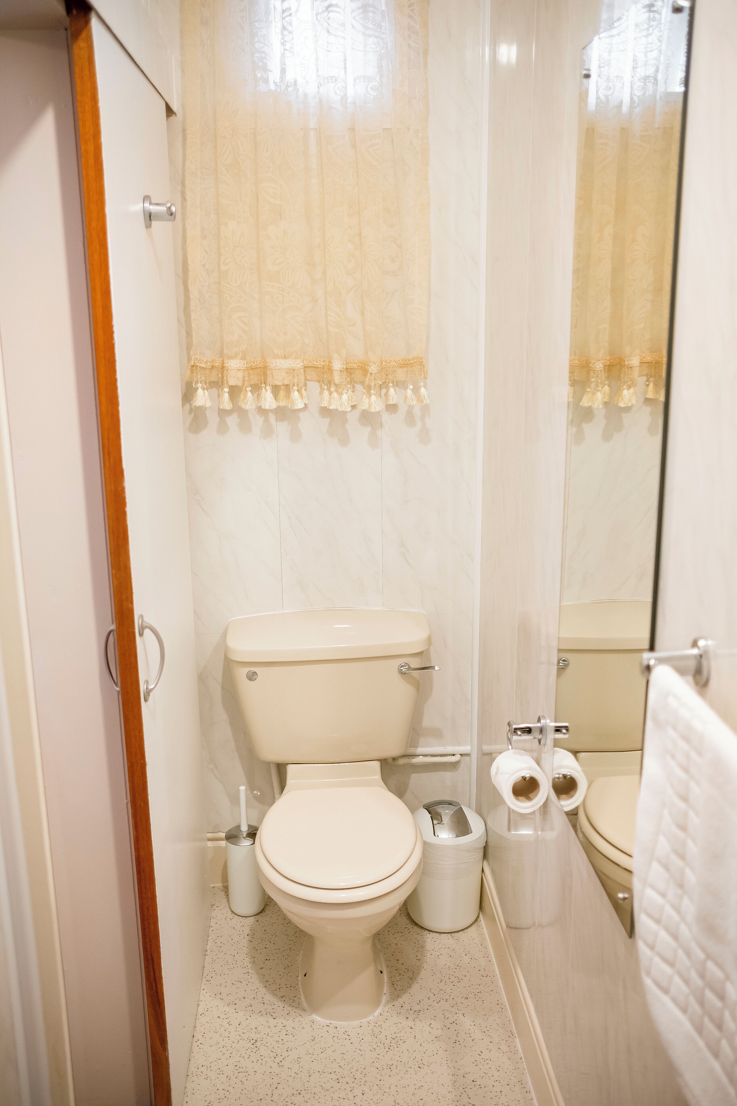 A small, modern bathroom with a toilet, bidet, and a mirror.