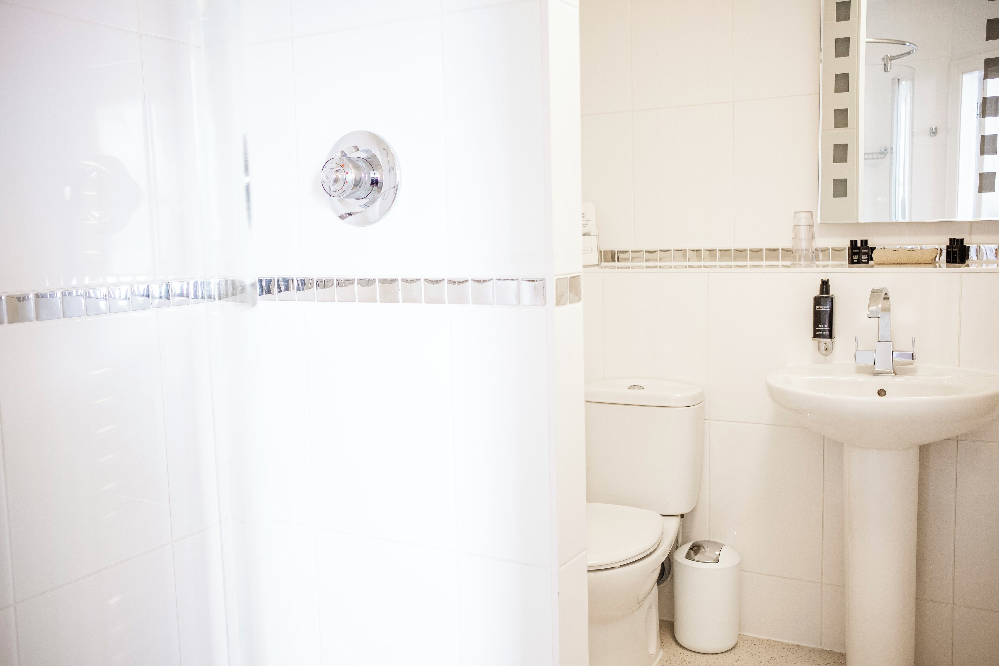 Un baño con ducha, inodoro y lavabo.