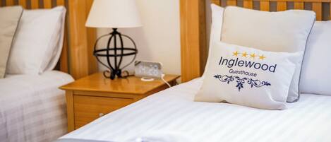 A hotel room with two beds, a nightstand with a lamp, and a decorative globe.