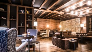 A modern living room with wooden beams, a fireplace, and a cozy seating area.