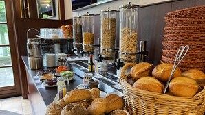 En buffet med forskelligt brød, dåser med pålæg og en kaffestation.