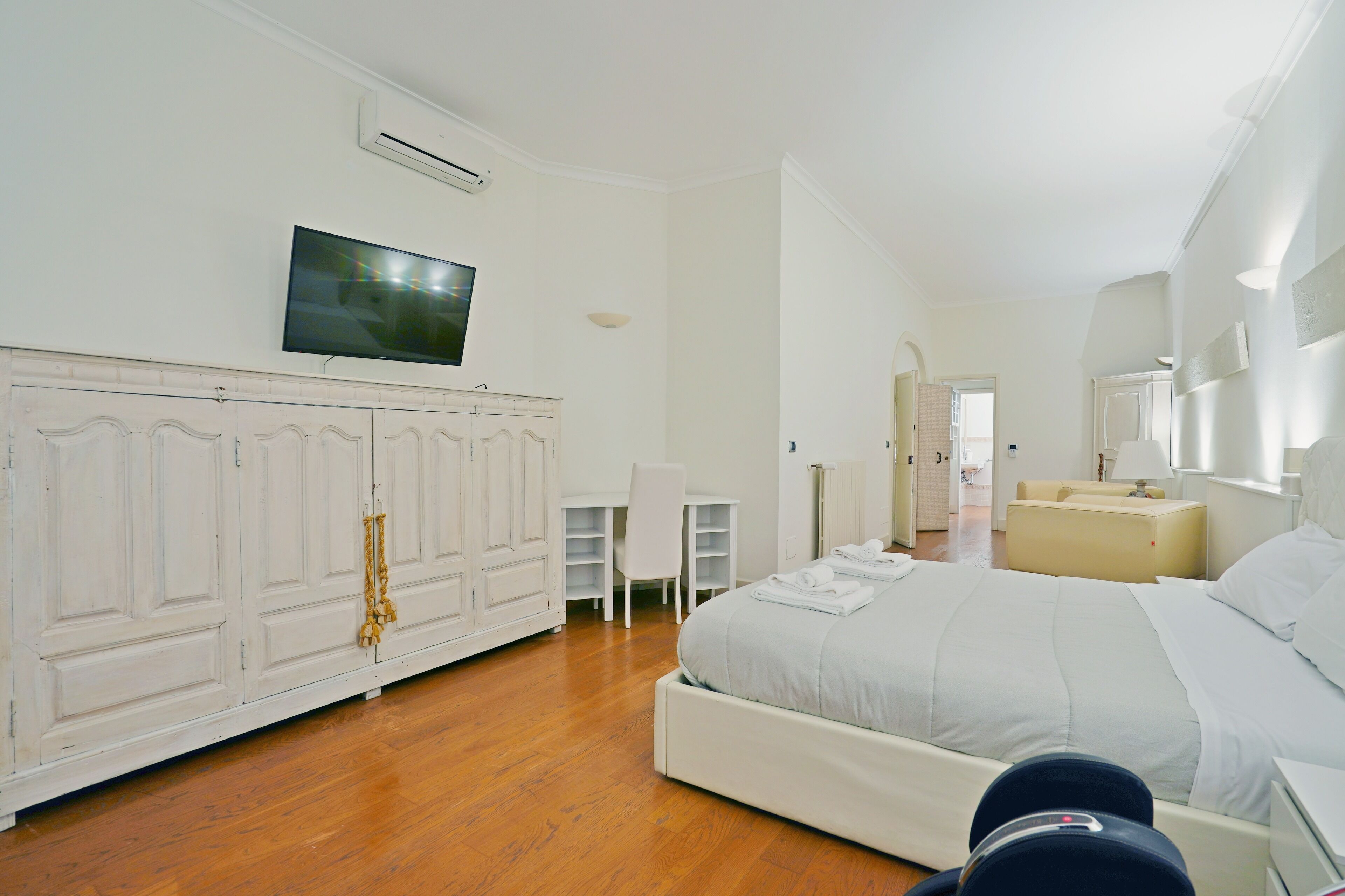 Une chambre d’hôtel équipée d’un lit, d’un bureau, d’une chaise, d’une armoire et d’un téléviseur.