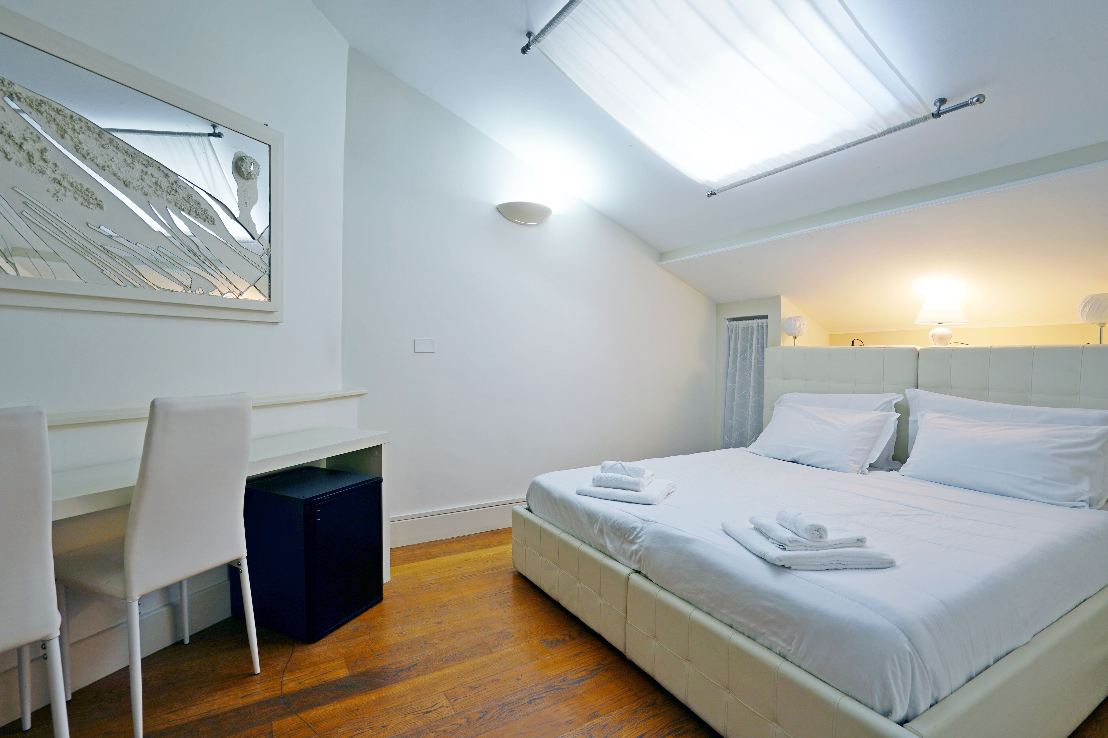 A modern bedroom with a bed, a desk, and a chair.