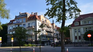 Ein mehrstöckiges Gebäude mit Balkonen, einer Fußgängerampel und einem Verbotsschild.
