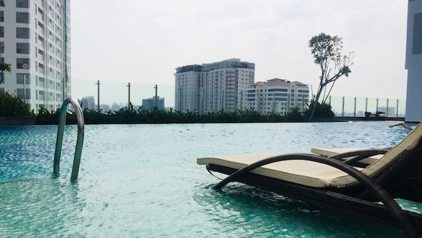 Piscina com espreguiçadeiras e escada.