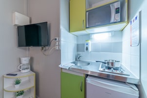 Cafetera o tetera, frigorífico, microondas y placa de cocina