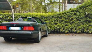 A parked convertible car with a visible license plate and a rear view of the vehicle.