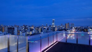 A cityscape at dusk with a modern building in the center. - The OneFive Osaka Namba Kuromon (Osaka)