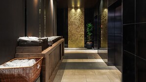 A modern lobby with a reception desk, a potted plant, and a check-in counter. - The OneFive Osaka Namba Kuromon (Osaka)