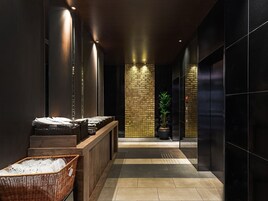 A modern lobby with a reception desk, a potted plant, and a check-in counter.