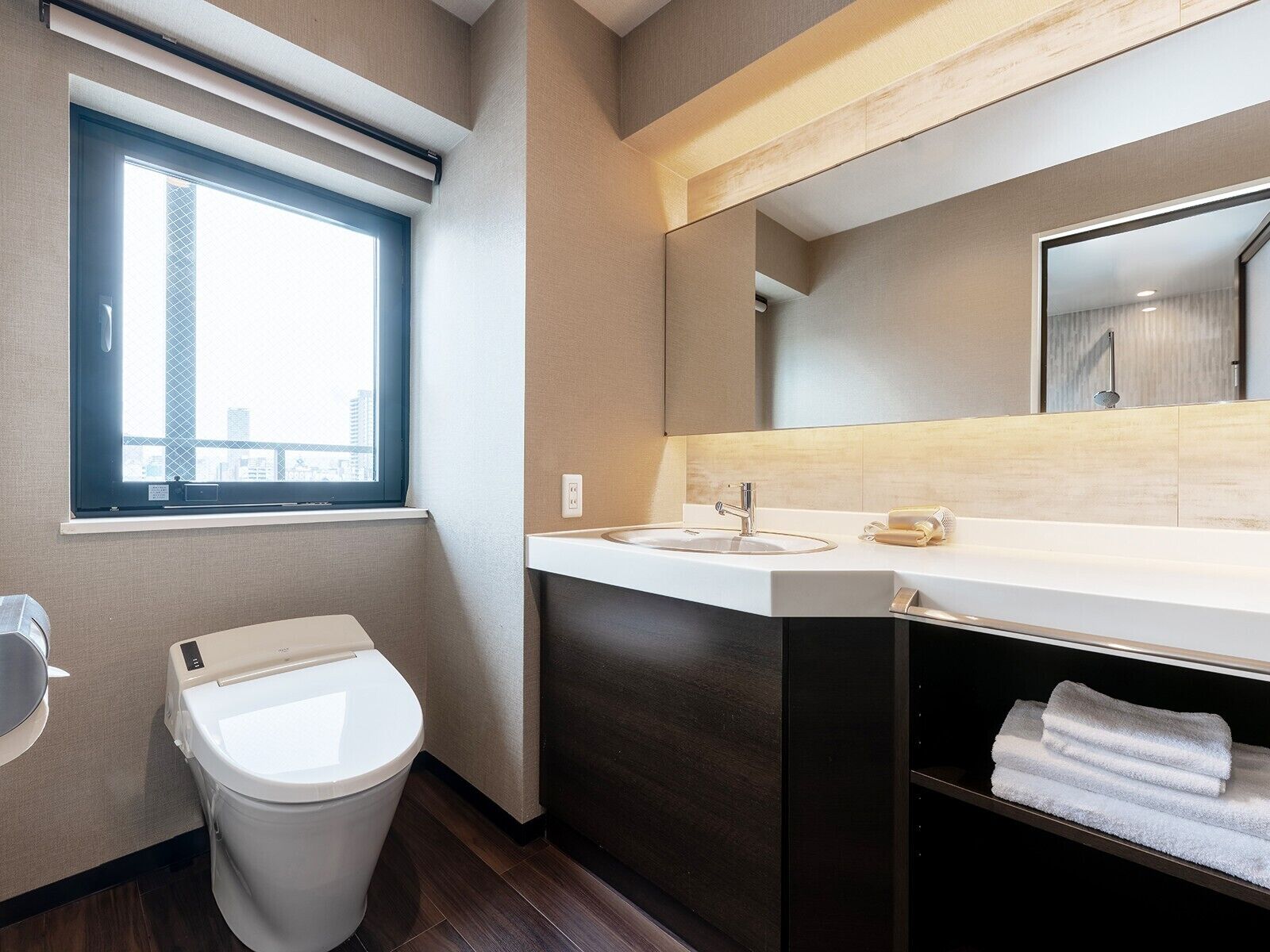 A modern bathroom with a toilet, sink, and towel rack.