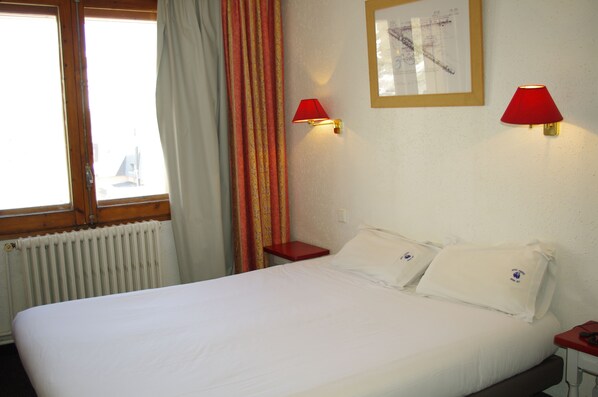 A hotel room with a large bed, two bedside tables, a window with curtains, and two wall-mounted lamps. - Hotel Panda (Pas de la Casa)