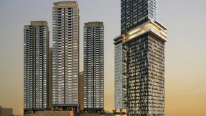 Een hoog gebouw complex met meerdere torens, met een modern architectonisch ontwerp en veel glas en staal.