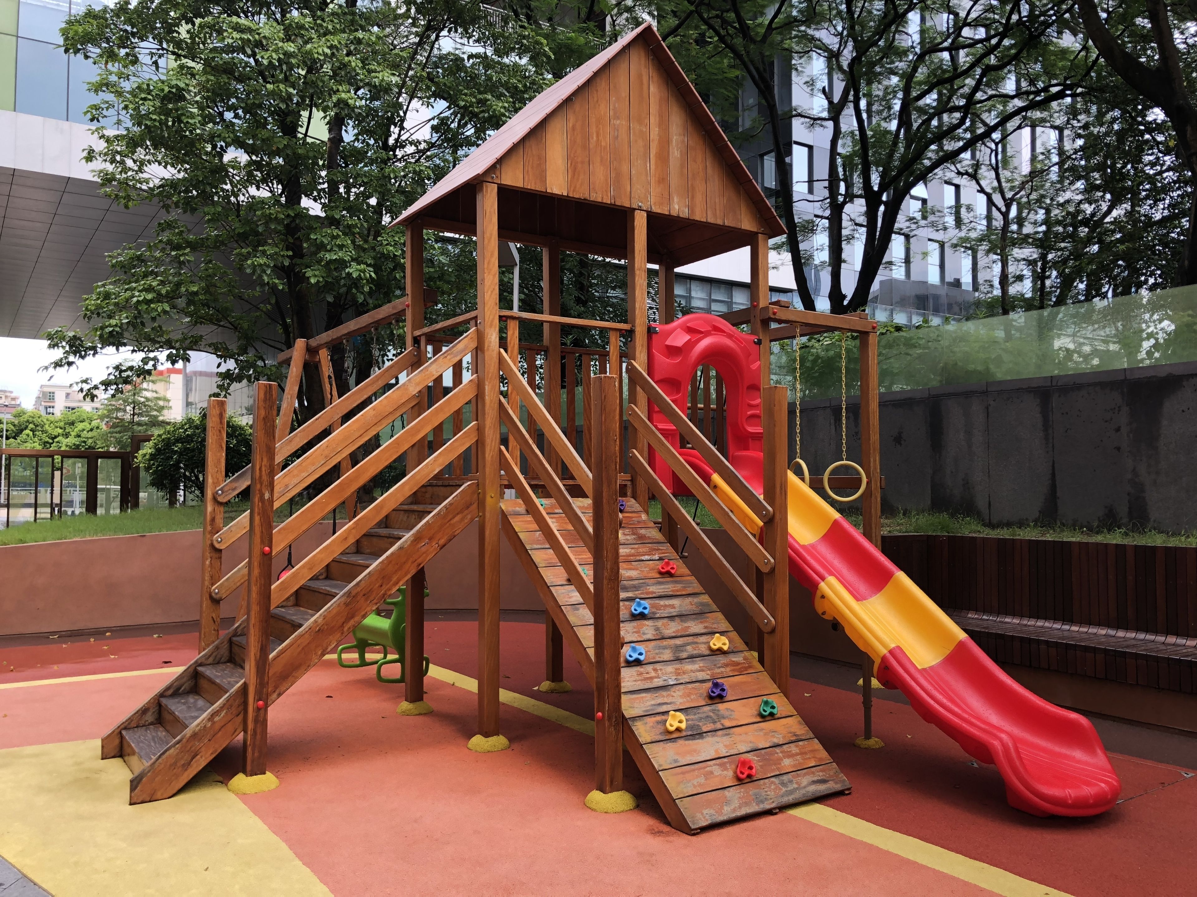 A wooden play structure with a slide and climbing steps.