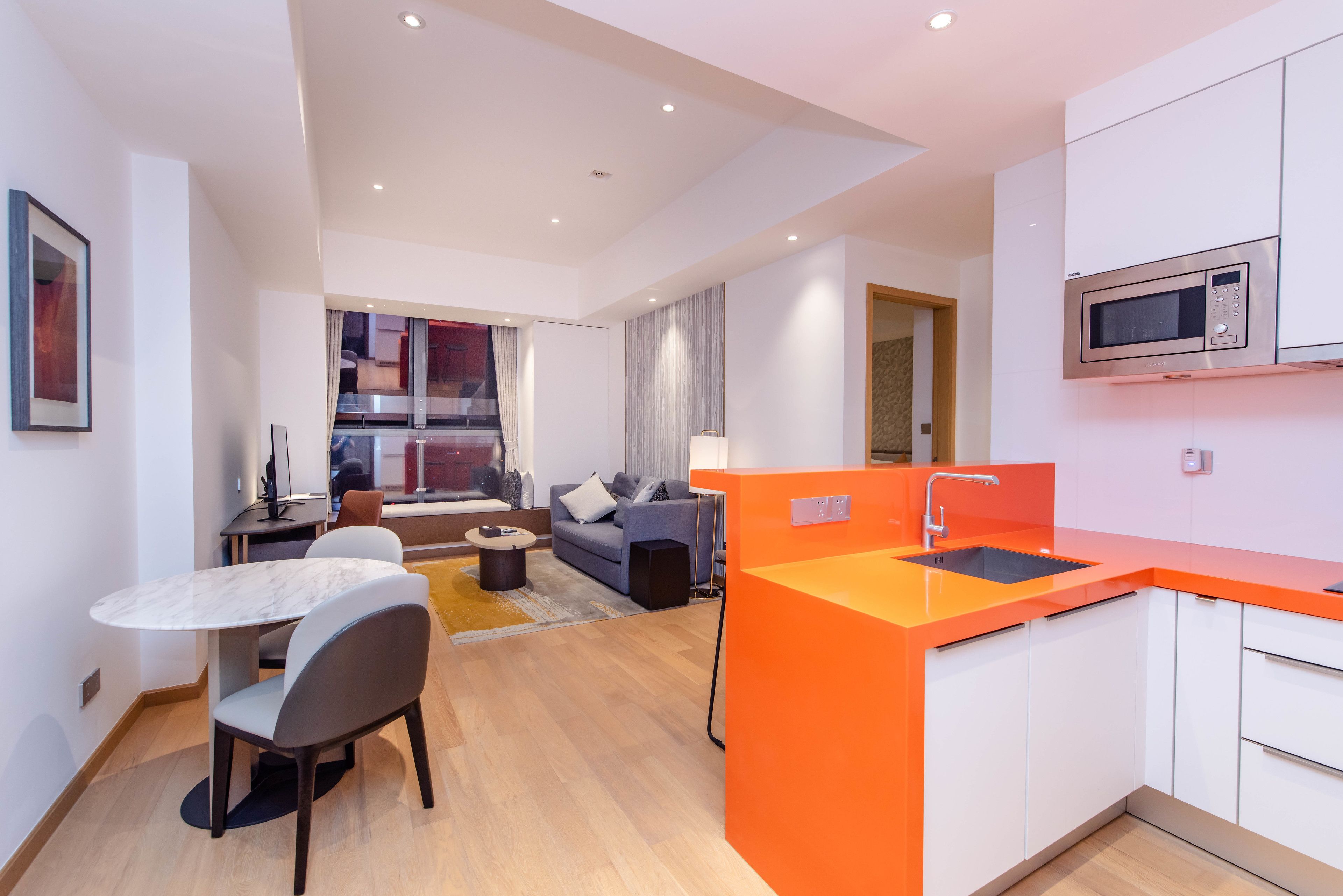 Una cocina moderna con microondas, un lavabo y una zona de comedor con mesa y sillas.