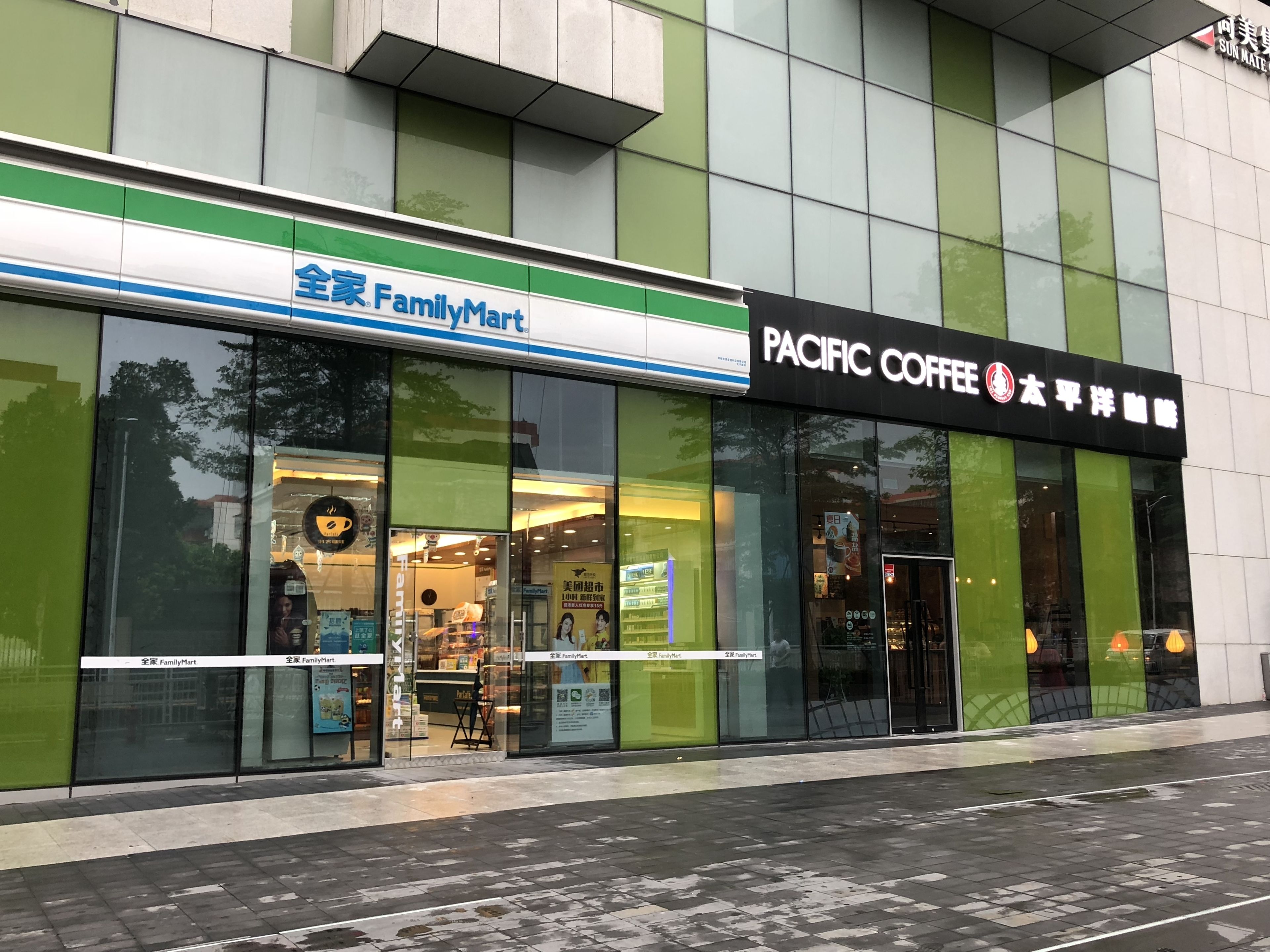 A FamilyMart and Pacific Coffee store with large glass windows and a green facade.