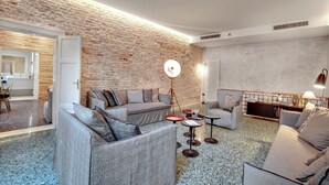 A modern living room with a brick wall, a sofa set, a coffee table, and a lamp.