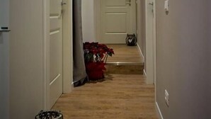 A narrow hallway with wooden flooring, white walls, and closed doors on either side. - St. Peter's Luxury Rooms (Rome)