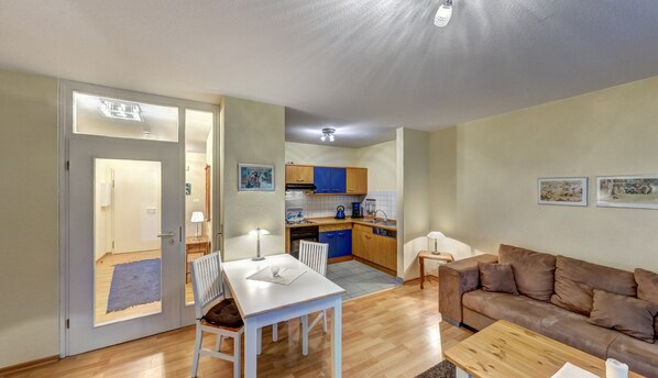 A compact living space with a dining area, a kitchenette, a sofa, and a coffee table.