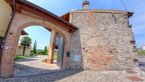 Un bâtiment en pierre avec une arche en briques menant à une entrée pavée.