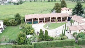 Un grand bâtiment doté d’une cour intérieure, entouré de champs verdoyants et d’arbres.