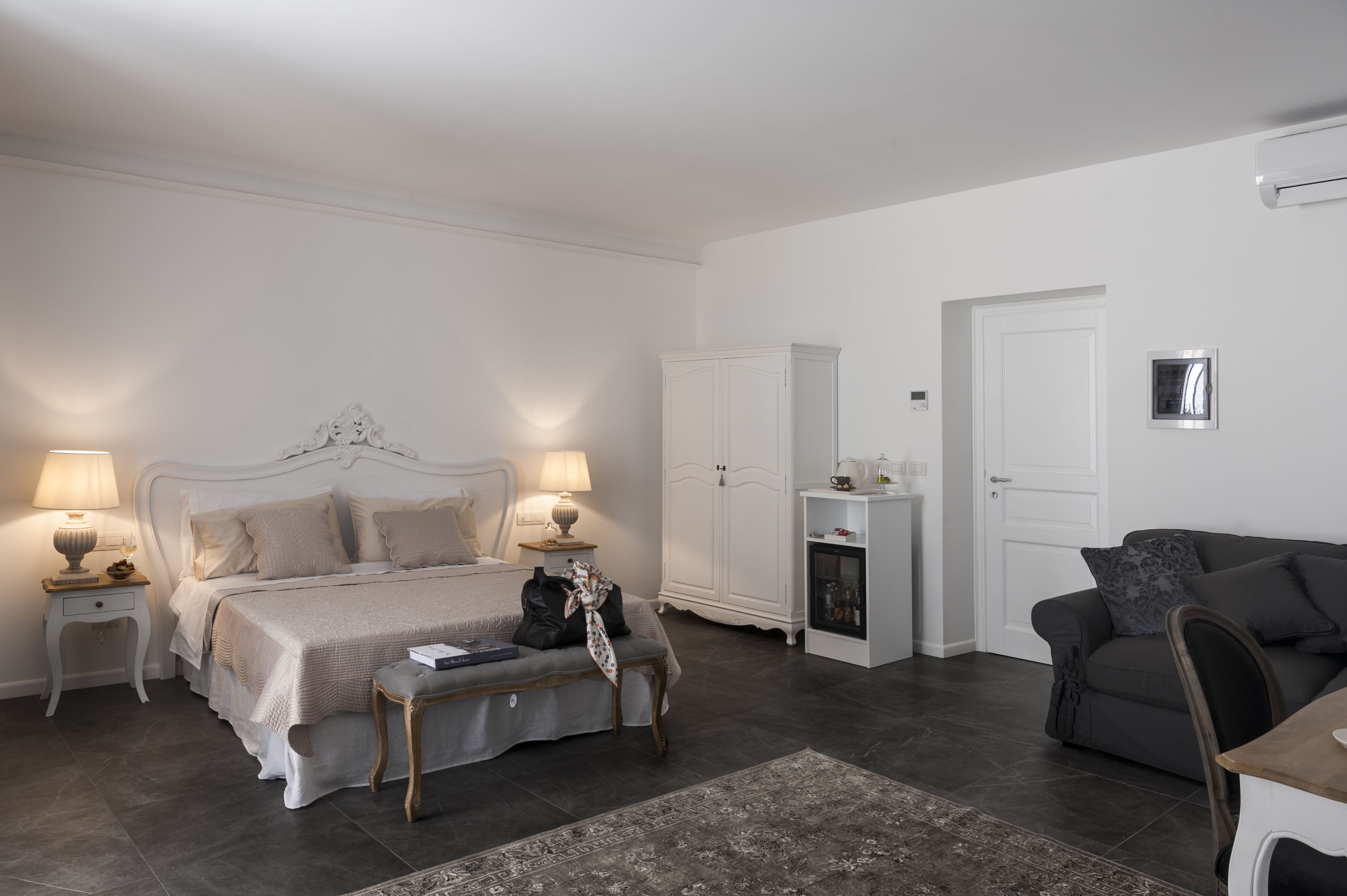A bedroom with a bed, bedside tables, a wardrobe, a desk, and a chair.