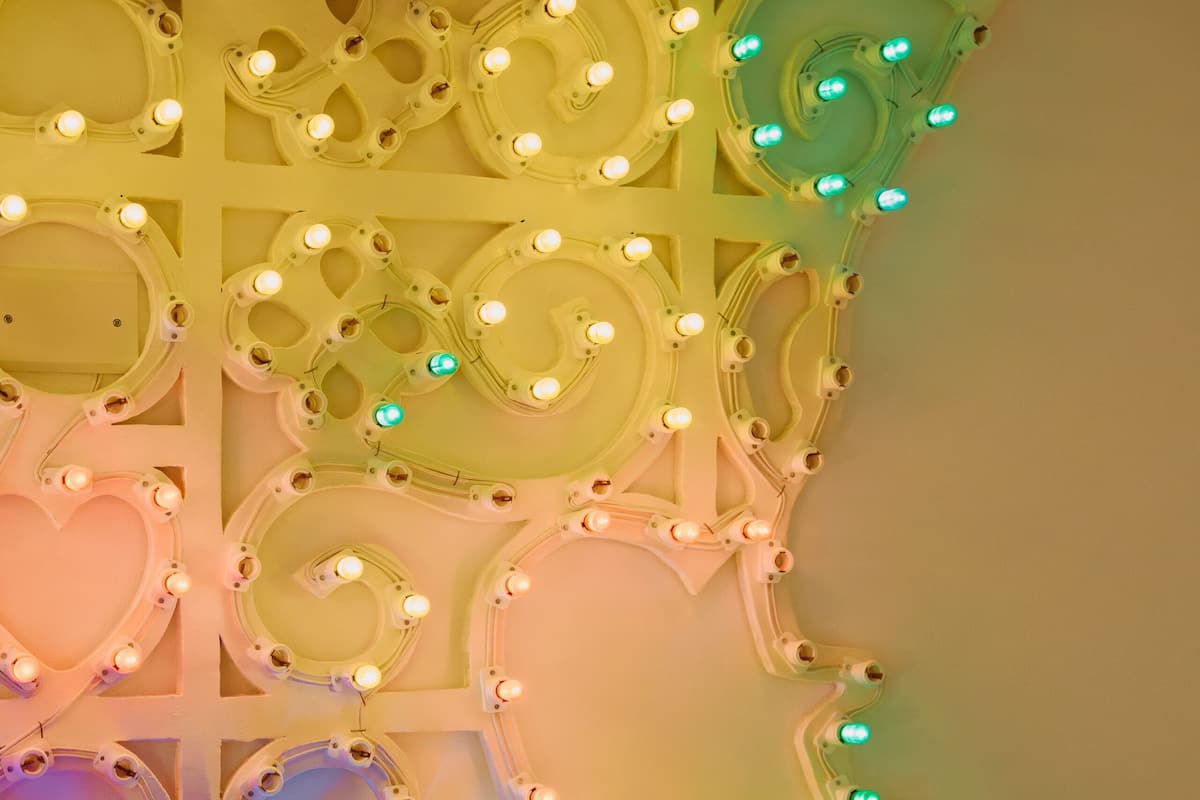 Una pared con una lámpara decorativa que presenta corazones y diseños circulares.