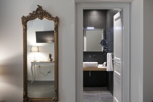 Un bagno con uno specchio grande e decorato, un lavabo e un mobile vanità con una lampada.