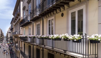Una fila di edifici con balconi, alcuni dei quali ornati da fioriere.