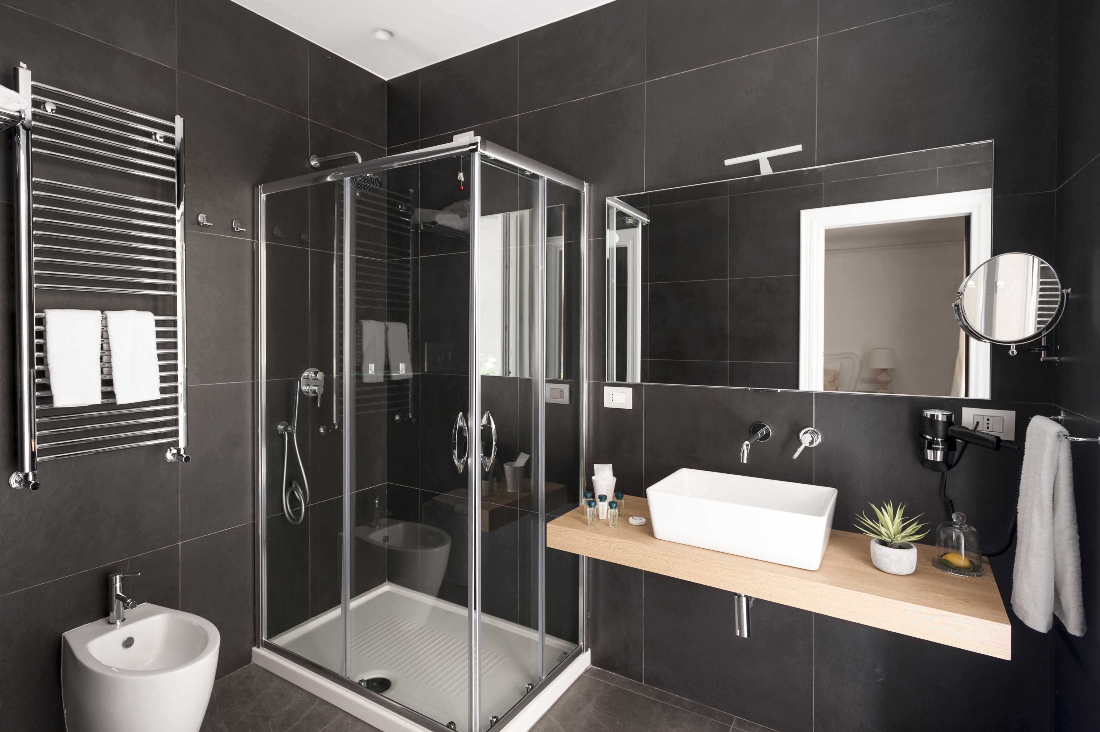 A modern bathroom with a glass-enclosed shower, a white sink, and a mirror.