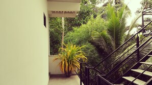 A staircase leading to a covered outdoor area with lush greenery and a potted plant. - Lara's Place Unawatuna (Unawatuna)
