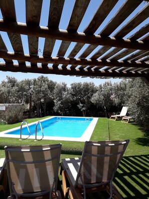 A pool area with two lounge chairs and a pergola overhead. - Agroturismo La Gayria (Tuineje)