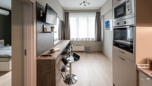 Eine moderne Küche mit Einbauofen, Mikrowelle und einer Essecke mit Barhocker.