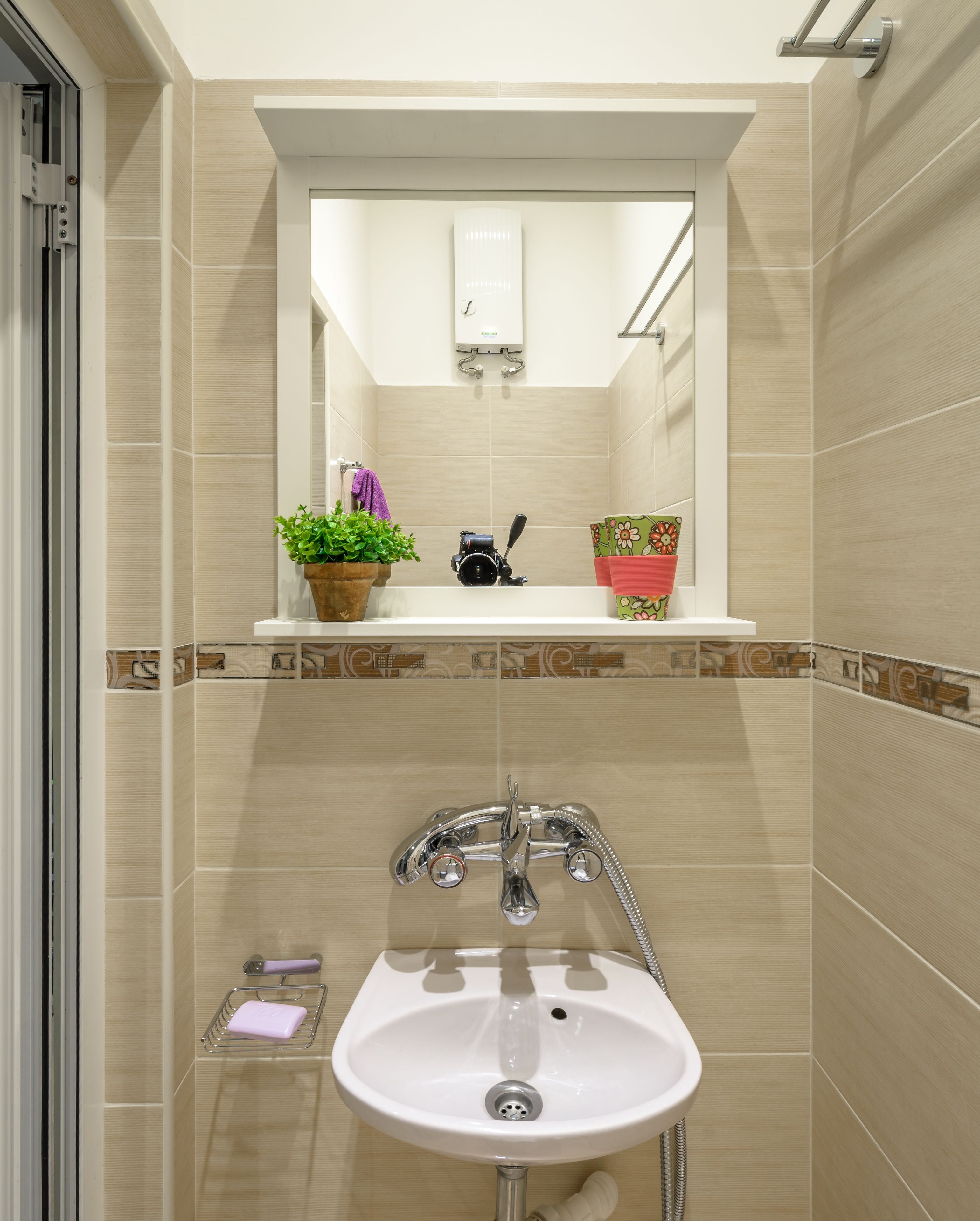 A bathroom with a sink, mirror, and shower.