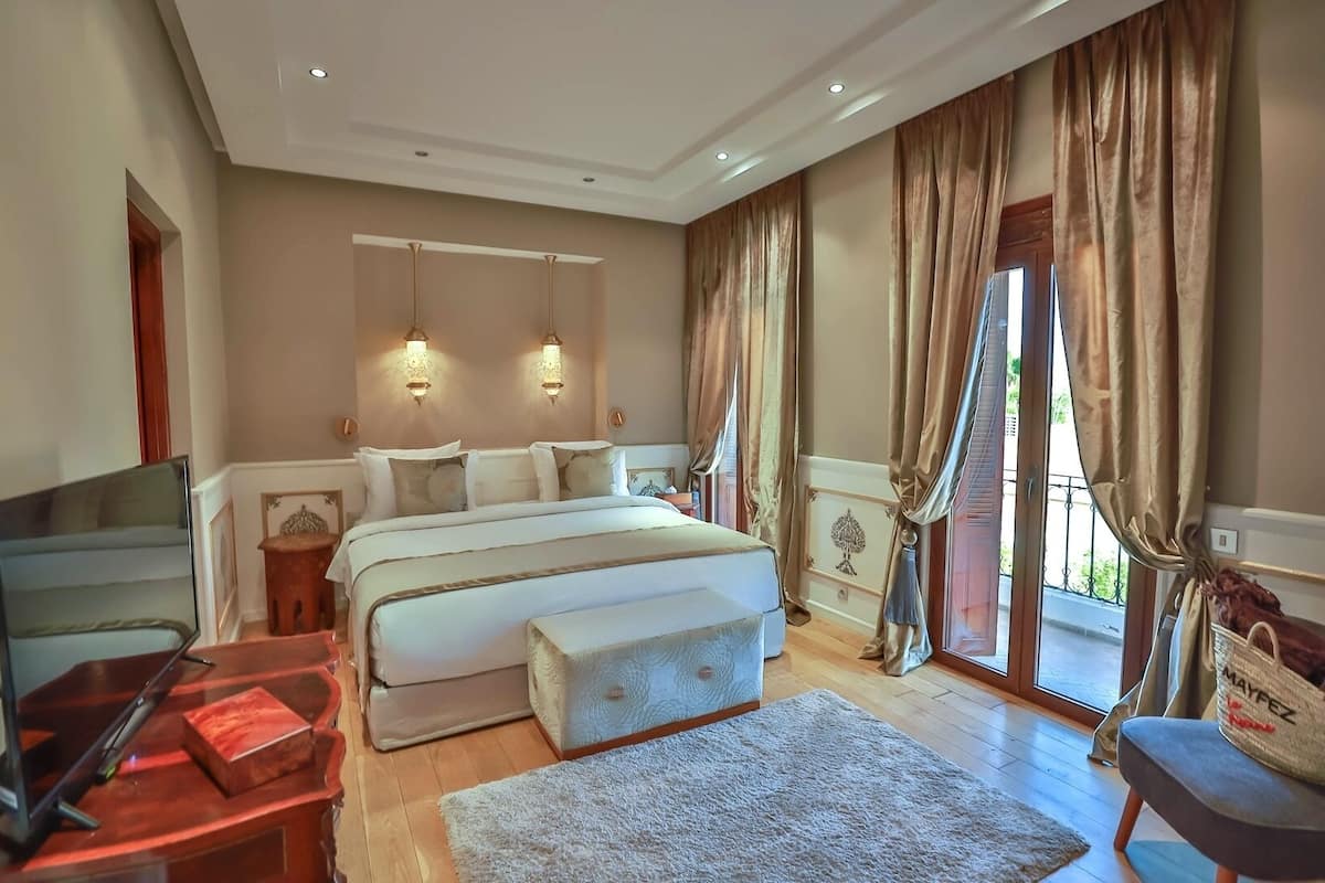 Um quarto espaçoso com uma cama grande, um espaço para sentar e vista para o exterior.