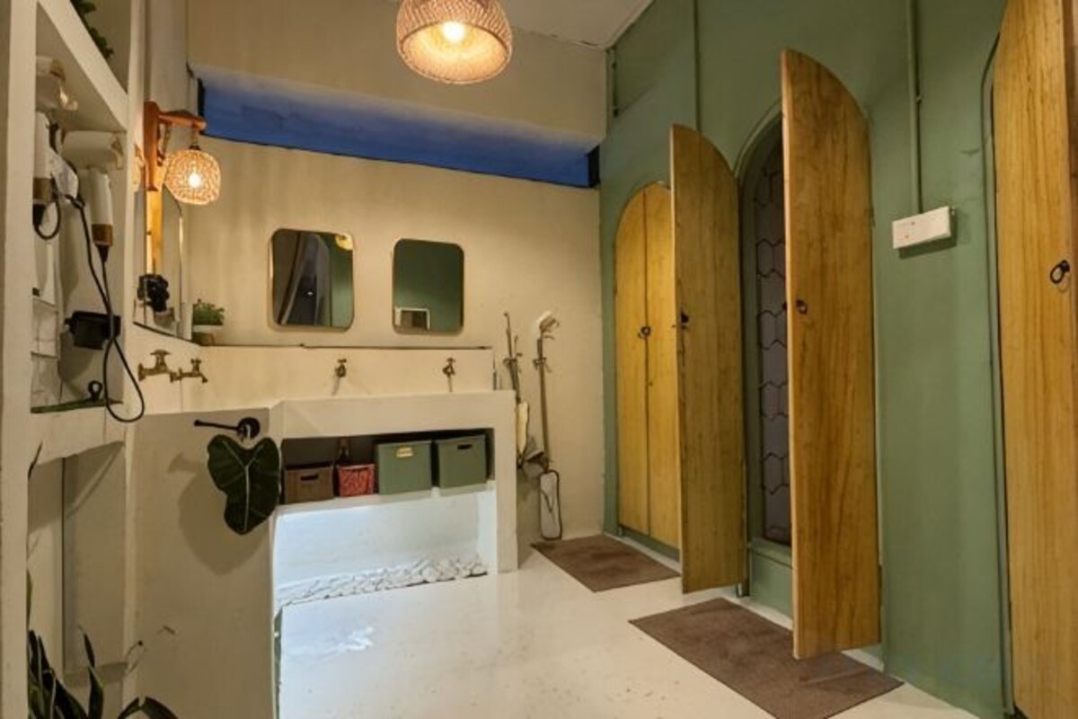 A bathroom with a white sink, wooden doors, and a mirror above the mirror.
