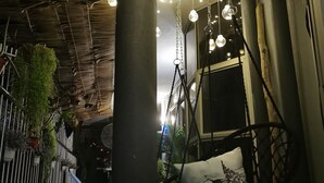 A modern interior with hanging spherical lights, a swing chair, and a staircase. - The Village (Semporna)