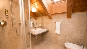 A modern bathroom with a glass-enclosed shower, a freestanding bathtub, and a sink.