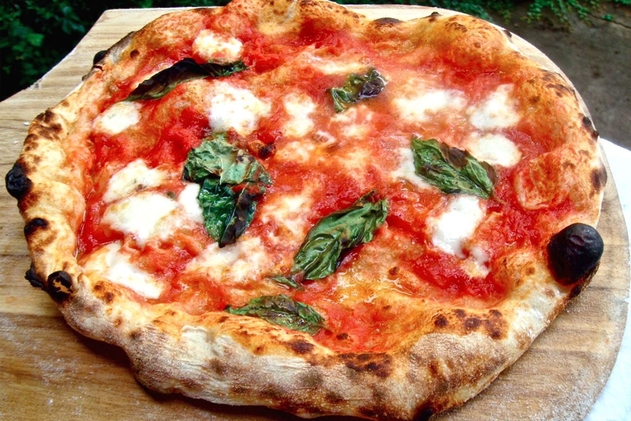 A pizza on a wooden board.