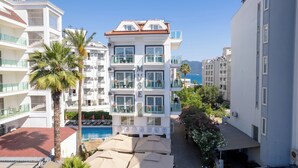 A multi-story hotel with balconies, a swimming pool, and a view of the sea. - Muse No:1 (Marmaris)
