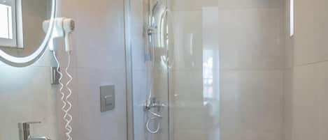 A modern bathroom with a white vanity, a glass-enclosed shower, and a toilet.