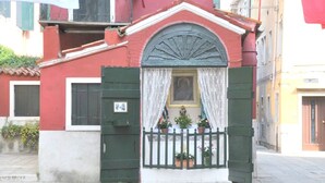 A building with a red facade, a white door, and a green gate. - Venice Giardini Biennale Apartment (Venice)