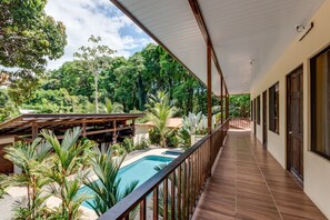 A covered balcony with a pool, surrounded by tropical vegetation and a view of the landscape. - Tropical Beach (Bahía Ballena)