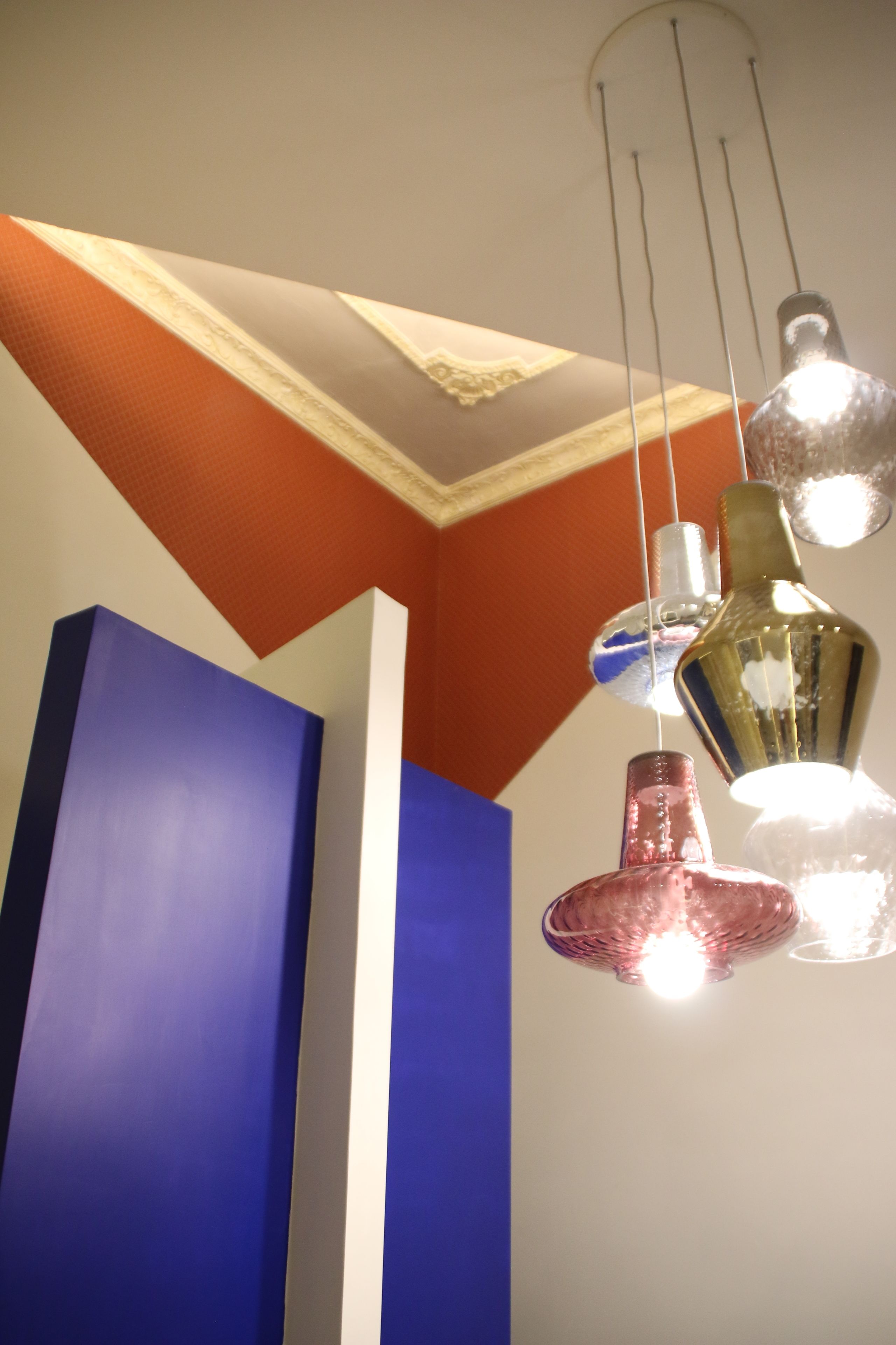 A ceiling with a geometric pattern and pendant lights.