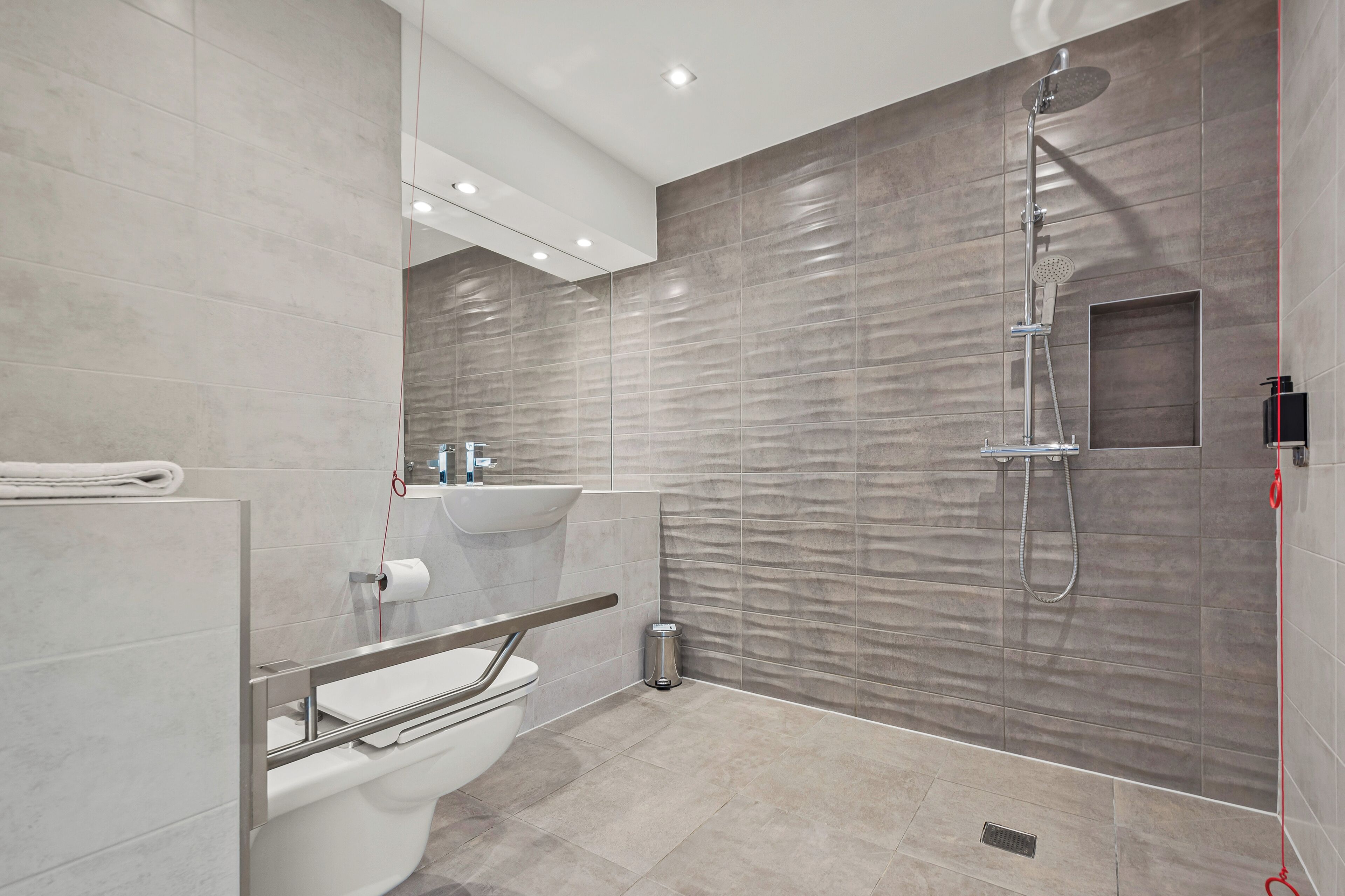 Un baño moderno con inodoro, lavamanos y ducha.