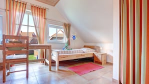 A bedroom with a wooden bed, a desk, and a chair. - Ferienpark Am Meer Katamaran 1 (Butjadingen)