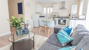 Un appartement moderne comprenant un coin repas, une kitchenette et un salon.